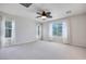 Primary bedroom featuring carpet flooring, ceiling fan, and lots of natural light from the large windows at 1427 Brushback Ave, Henderson, NV 89074