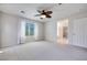 Bright primary bedroom features carpet flooring, a ceiling fan and great natural light from the large window at 1427 Brushback Ave, Henderson, NV 89074