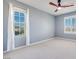 Bright bedroom with two windows, ceiling fan, and neutral carpeting at 1427 Brushback Ave, Henderson, NV 89074