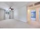 Bright bedroom features a ceiling fan, carpeted floors, and two entry doors at 1427 Brushback Ave, Henderson, NV 89074
