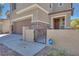 Close-up of the front entrance featuring stone accents, a brown garage door and entrance door and an ADT security sign at 1427 Brushback Ave, Henderson, NV 89074