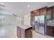 Open concept kitchen featuring granite counters, island, stainless steel appliances and white tile flooring at 1427 Brushback Ave, Henderson, NV 89074