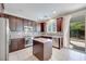 Open-concept kitchen featuring dark wood cabinets, granite countertops, and stainless steel appliances at 1427 Brushback Ave, Henderson, NV 89074