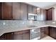 Close up of the kitchen featuring stainless steel appliances, tile backsplash and granite counters at 1427 Brushback Ave, Henderson, NV 89074