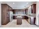 Open-concept kitchen featuring dark wood cabinets, granite countertops, and stainless steel appliances at 1427 Brushback Ave, Henderson, NV 89074