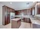 Well-lit kitchen features stainless steel appliances, granite counters, and dark wood cabinetry at 1427 Brushback Ave, Henderson, NV 89074