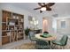 Bright living room features a wooden bookshelf, modern desk, and stylish round table with green chairs at 1427 Brushback Ave, Henderson, NV 89074