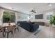 Open-concept living room featuring tile floors, modern furniture, and large windows with views of the backyard at 1427 Brushback Ave, Henderson, NV 89074