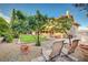 Expansive backyard boasting a lush lawn, mature trees, brick-lined garden beds, and a comfortable seating area at 1546 Georgia Ave, Boulder City, NV 89005