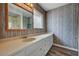 Bathroom with a long countertop, framed mirror, vanity lighting, linoleum flooring, and striped wall paper at 1801 S 15Th St, Las Vegas, NV 89104