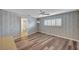 Bedroom with light-colored wallpaper, wood-look floors, a ceiling fan, and a door to the bathroom at 1801 S 15Th St, Las Vegas, NV 89104