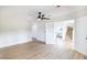Open bedroom view with ceiling fan, wood-look flooring, and doorway to stairs and laundry at 1891 Brian Rd, Pahrump, NV 89048