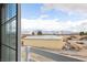 Captured through a window, a view of a landscape featuring mountains, storage building and varied debris at 1891 Brian Rd, Pahrump, NV 89048