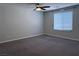 Bright bedroom with a ceiling fan, a large window, and soft carpet flooring at 22 Kaku Ridge Way, Las Vegas, NV 89183