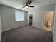 Bedroom features neutral walls, gray carpet, window with blinds and ensuite bathroom at 22 Kaku Ridge Way, Las Vegas, NV 89183