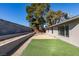 Expansive backyard with artificial turf, tiered planters, mature trees, and desert landscaping, creating a serene outdoor space at 2205 Mccoig Ave, Las Vegas, NV 89119