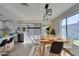 Bright dining area with modern light fixture, wood table and views of the backyard through the sliding glass doors at 2205 Mccoig Ave, Las Vegas, NV 89119