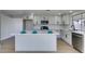 Modern kitchen features white cabinets, stainless steel appliances, island with quartz countertop and stylish finishes at 2205 Mccoig Ave, Las Vegas, NV 89119