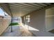 Covered patio with concrete flooring, offering a view of the well-maintained backyard with artificial turf and greenery at 2205 Mccoig Ave, Las Vegas, NV 89119