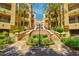 Beautiful courtyard entrance with palm trees and well-maintained landscaping leading to condo buildings at 230 E Flamingo Rd # 115, Las Vegas, NV 89169