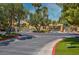 Gated community entrance with manicured landscaping, mature trees, and controlled access at 230 E Flamingo Rd # 115, Las Vegas, NV 89169