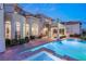 A luxurious backyard area with a pool, spa, spiral staircase, and manicured landscaping at 2660 Mirabella St, Henderson, NV 89052
