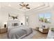 Comfortable bedroom with a ceiling fan, large window, and a sitting area at 2660 Mirabella St, Henderson, NV 89052