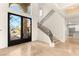 A beautiful entryway with wrought iron and glass front door and a staircase at 2660 Mirabella St, Henderson, NV 89052