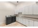Spacious laundry room featuring modern washer and dryer units, ample storage cabinets, and a sink at 2660 Mirabella St, Henderson, NV 89052