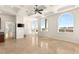 Open living space featuring arched windows, a tray ceiling, and neutral walls creating an airy atmosphere at 2660 Mirabella St, Henderson, NV 89052