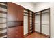 A large walk-in closet with custom built-in shelving and wood floor at 2660 Mirabella St, Henderson, NV 89052