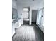 Bright bathroom with double vanity, gray wood-look floors, and glass shower enclosure at 290 Mount Williamson St, Henderson, NV 89015