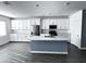Bright kitchen boasts white cabinets, stainless steel appliances, large island, and modern finishes at 290 Mount Williamson St, Henderson, NV 89015