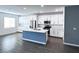 Open kitchen with stainless appliances, island, white cabinets, and hardwood floors at 290 Mount Williamson St, Henderson, NV 89015