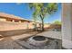 Large backyard featuring a lounge swing, fire pit, and low-maintenance gravel and stone landscaping at 317 Shimmering Moon St, Henderson, NV 89015