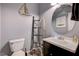 Nautical-themed half bathroom with round mirror, decorative ladder, and clean white toilet at 317 Shimmering Moon St, Henderson, NV 89015
