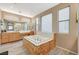 Bright bathroom with oversized tub, and vanity and sinks, and view to shower at 317 Shimmering Moon St, Henderson, NV 89015