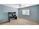 This bedroom is painted blue and features a large window with white blinds and a black desk at 317 Shimmering Moon St, Henderson, NV 89015