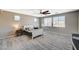 Spacious bedroom with wood-look floors, ceiling fan, and natural light from multiple windows at 317 Shimmering Moon St, Henderson, NV 89015