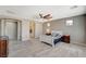 Open bedroom space with access to ensuite bath and walk in closet, wood-look floors and ceiling fan at 317 Shimmering Moon St, Henderson, NV 89015
