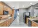 Spacious kitchen featuring wood cabinets, granite countertops, stainless steel appliances, and modern tile flooring at 317 Shimmering Moon St, Henderson, NV 89015