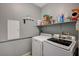 Functional laundry room includes modern washer and dryer with convenient shelving for storage at 317 Shimmering Moon St, Henderson, NV 89015