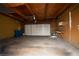 Spacious garage featuring a large roll-up door, concrete floor, and workbench at 3467 Garden East Dr, Las Vegas, NV 89121