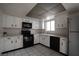 Efficient kitchen with white cabinetry, tile flooring, black appliances, and a window for natural light at 3467 Garden East Dr, Las Vegas, NV 89121
