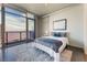 Bright bedroom features a large window with city views, a plush bed, and a concrete accent wall at 353 E Bonneville Ave # 746, Las Vegas, NV 89101