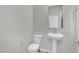 Bright powder room featuring a pedestal sink, toilet, and a well-lit mirror at 389 Scarlet Pine Ct, Henderson, NV 89044