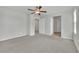 Spacious bedroom with neutral carpet, ceiling fan, and multiple doorways, creating a flexible living space at 389 Scarlet Pine Ct, Henderson, NV 89044
