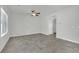 A spacious living room features neutral paint, tile floors, ceiling fan, and large window for natural light at 389 Scarlet Pine Ct, Henderson, NV 89044