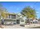 Two-story home features a two-car garage, balcony, and a lush, mature tree in the front yard at 401 Altamira Rd, Las Vegas, NV 89145