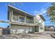 Two-story home features a two-car garage, balcony, and a lush, mature tree in the front yard at 401 Altamira Rd, Las Vegas, NV 89145